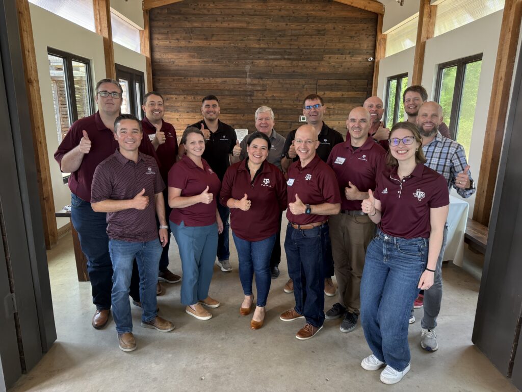 Image of 14 faculty and staff members smiling for a picture with thumbs up